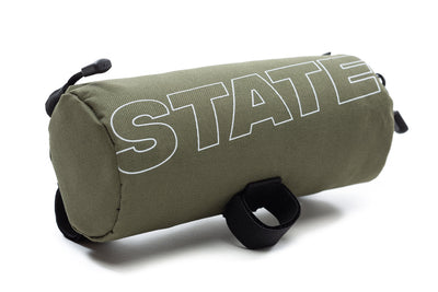 State Bicycle Co. All-Road handlebar bag in olive green with white STATE outline logo and black Velcro mounting loops
