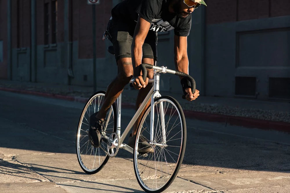 man riding fixed gear bike down road