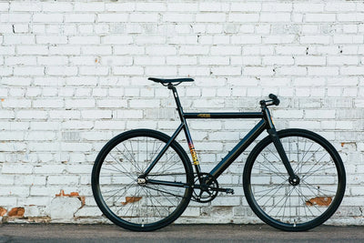 man riding fixed gear bike down road