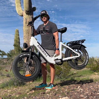A man carries the Kingbull Literider White folding electric bike