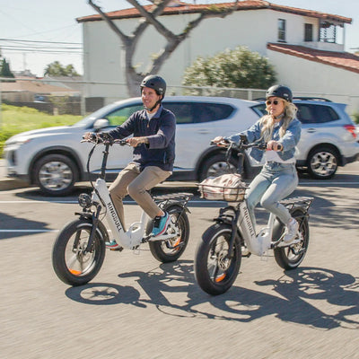 A man and a woman riding a Kingbull Literider folding bike on the road
