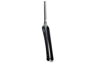 State Bicycle carbon fiber Monster gravel fork v2 — 3/4 view showing matte black carbon with SBC logo, wide tire clearance, and cage mounts